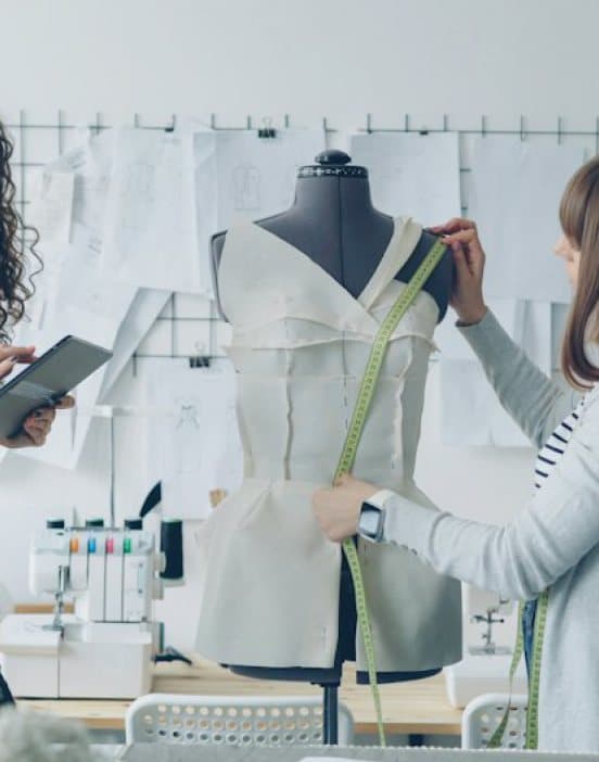 Our team fitting a garment on a dress form